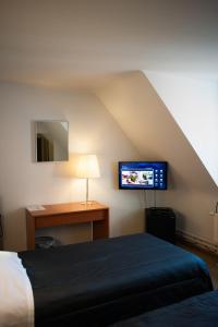 Un dormitorio con una cama, un escritorio y un televisor. en JFK Hotel Zelzate - Gent, en Zelzate 26 fotos más