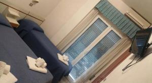 Un dormitorio con una cama azul y una ventana en Hotel Delizia, en Rímini