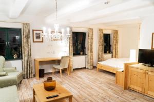 ein Wohnzimmer mit einem Bett und einem Tisch in der Unterkunft Forsthaus Wörnbrunn in Grünwald