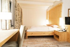Schlafzimmer mit einem Bett und einem Schreibtisch in der Unterkunft Forsthaus Wörnbrunn in Grünwald