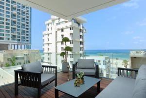 balcone con sedie, tavolo e vista sull'oceano di High Standing at Hayarkon by HolyGuest a Tel Aviv