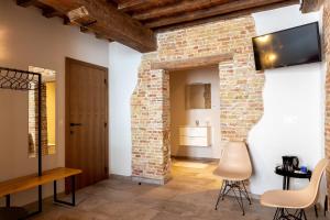 a room with a brick wall and a tv on the wall at La Clé Brugge in Bruges