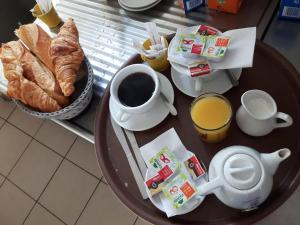 a table with a cup of coffee and a plate of bread at Le Cocardier in Saintes-Maries-de-la-Mer