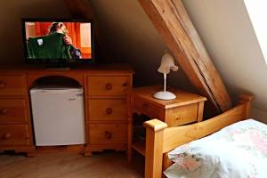a bedroom with a dresser with a television on it at Pension Grant Lux Znojmo in Znojmo
