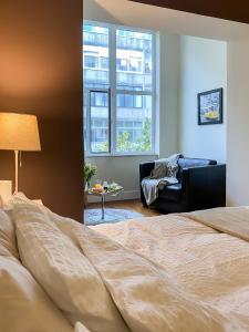 um quarto com uma cama, uma cadeira e uma janela em Guest House Bairro Azul em Lisboa