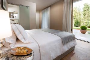 een slaapkamer met een groot bed en een groot raam bij Villa Carlotta by HMZ Villas in Vabriga