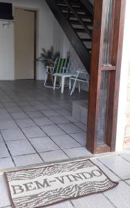 a rug on a porch with a table and chairs at Casa na Ilha da Croa in Barra de Santo Antônio