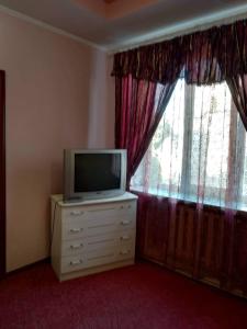 a television sitting on a dresser in front of a window at Готель Турист in Mohyliv-Podilʼsʼkyy