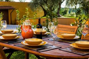 uma mesa de madeira com pratos e copos e uma garrafa de vinho em Villa Elisabetta em Trequanda