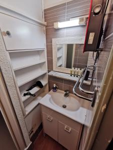 a small bathroom with a sink and a mirror at Pluton B63 in Les Deux Alpes