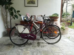 uma bicicleta vermelha estacionada ao lado de uma casa em Relais Sassetti em Pisa