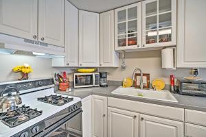 a kitchen with white cabinets and a stove top oven at Red Lodge Retreat with Yard - Walk to Restaurants! in Red Lodge
