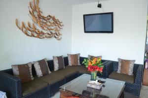 ein Wohnzimmer mit einem Sofa mit Kissen und einem Tisch in der Unterkunft Jas Boutique Villas in Seminyak