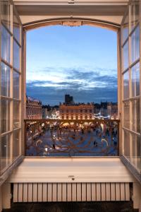 a large window with a large clock on it at Grand Hotel De La Reine - Place Stanislas in Nancy