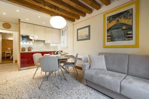 ein Wohnzimmer mit einem Sofa und einem Tisch in der Unterkunft Rialto - Sant'Aponal Prestige in Venedig