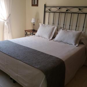 1 dormitorio con 1 cama grande con almohadas blancas en Carmen en Vaqueros