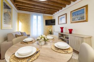 ein Esszimmer mit einem Tisch und einem Sofa in der Unterkunft Rialto - Sant'Aponal Prestige in Venedig