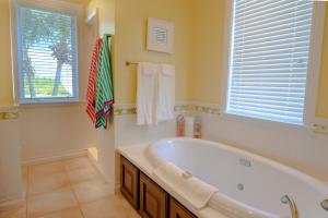 a large bathroom with a tub and a window at Cape Santa Maria Beach Resort & Villas in Seymourʼs