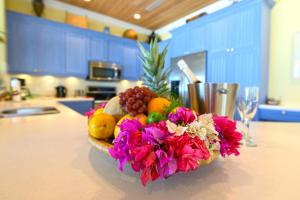 un bol de frutas y flores en un mostrador en Cape Santa Maria Beach Resort & Villas en Seymourʼs