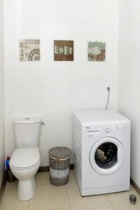 a bathroom with a washing machine and a toilet at La corderie du Lude in Granville