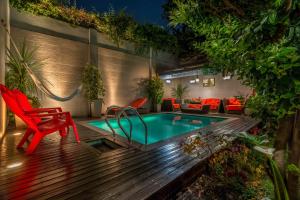 a patio with a plunge pool and a red chair at Duque Hotel Boutique & Spa in Buenos Aires