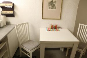 ミュルハイム・アン・デア・ルールにあるApartment mit Gartenblick und kleines Apartment im 3 Familienhausのデスク(椅子2脚付)、白いテーブル(ペン付)