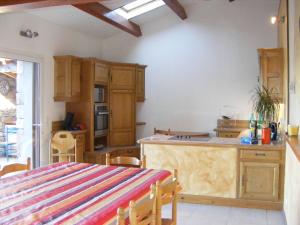 a kitchen with wooden cabinets and a kitchen island at Lestival, le gîte in Usclas-du-Bosc