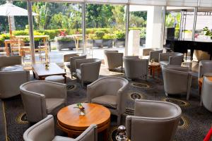 a restaurant with chairs and tables and a piano at Carlton Madagascar in Antananarivo