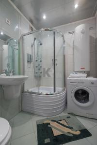 a bathroom with a shower and a washing machine at ОК! Красноармейская, 101 in Tomsk