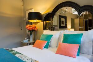 een slaapkamer met een bed met kleurrijke kussens bij The Gallery Studios in Porto