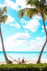 un gruppo di persone seduti su un'amaca in spiaggia di Cape Santa Maria Beach Resort & Villas a Seymourʼs