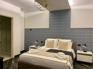 sypialnia z dużym łóżkiem i niebieską tapetą w obiekcie Gatto Bianco Le Mura w Bergamo