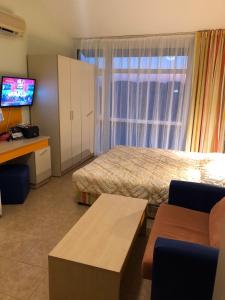 ein Hotelzimmer mit einem Bett und einem Fernseher in der Unterkunft Elit 2 Apartment in Sonnenstrand