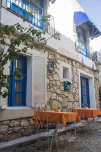 two tables and chairs in front of a building at Lavinia Otel in Cesme