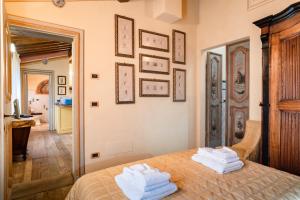 een slaapkamer met een bed met handdoeken erop bij Le Virtù in Migliarino