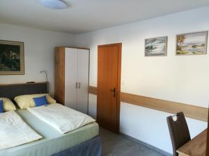 a bedroom with a bed and a desk and a door at Apartment Waldhaus Opitz in Zell am See