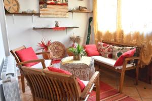 un soggiorno con divano, sedie e tavolo di B&B Mitzixeddas Sa Domu de Braxia a Màndas