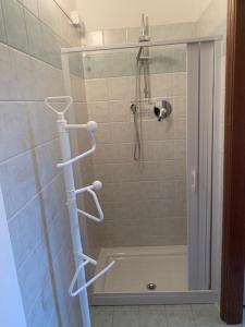 y baño con ducha con estantes blancos. en Loft Bergamo Casa Vacanze, en Bérgamo