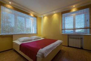 a bedroom with a large bed with two windows at ОК! Красноармейская, 101 in Tomsk