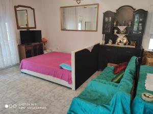- une chambre avec un lit, un canapé et un miroir dans l'établissement Fanis & Xenia's Residence, à Samothráki