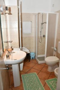 uma casa de banho com um lavatório, um WC e um chuveiro em B&B Mitzixeddas Sa Domu de Braxia em Màndas