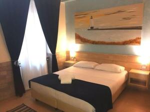 a bedroom with a bed and a painting on the wall at Fiumicino Airport B&B Deluxe in Fiumicino