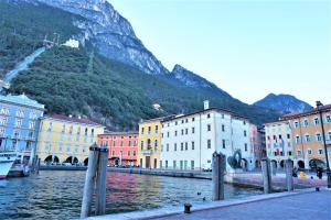 eine Gruppe von Gebäuden neben einem Fluss mit einem Berg in der Unterkunft Garda Smile in Riva del Garda