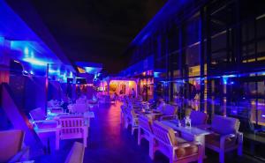 a restaurant with white tables and chairs and purple lights at Jeddah Oasis Hotel in Jeddah +77 photos
