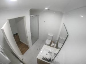 uma casa de banho com um espelho, um lavatório e um WC. em 1 Bdrm Close Airport/Shops, WIFI, NETFLIX, PARKING em Perth