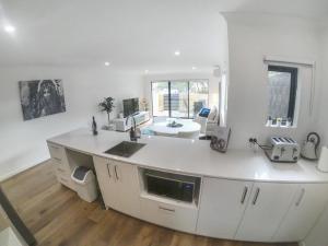 a white kitchen with a sink and a counter at 1 Bdrm Close Airport/Shops, WIFI, NETFLIX, PARKING in Perth
