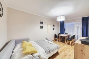 a bedroom with a bed and a dining room at Dream Loft Podwale Staromiejskie in Gdańsk