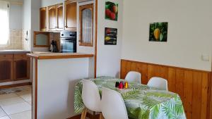une cuisine avec une table et des chaises dans l'établissement Le Gecko Vert, à Manapany-les Bains
