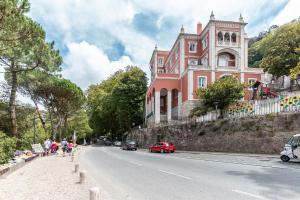 a large pink building on the side of a road at Wine Inn Studio in Sintra