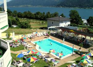 una piscina con sombrillas y sillas y un hotel en All Inclusive Hotel Sonnenhügel en Sattendorf